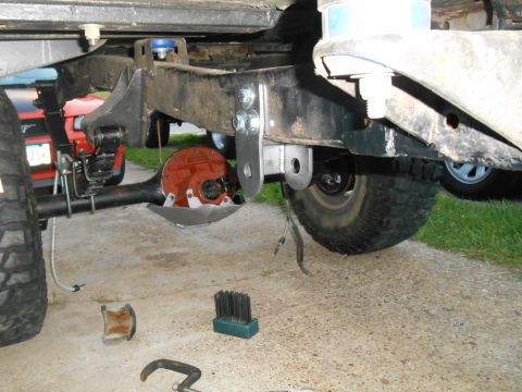 1972 Ford Bronco - A close-up view of the rear axle and suspension components of a vehicle, likely a Ford Bronco, as it is being worked on. The image shows cu…