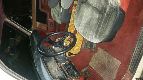 1988 Ford Bronco - The interior of this 1988 Ford Bronco features a dark dashboard, a custom steering wheel, and plush carpeting.