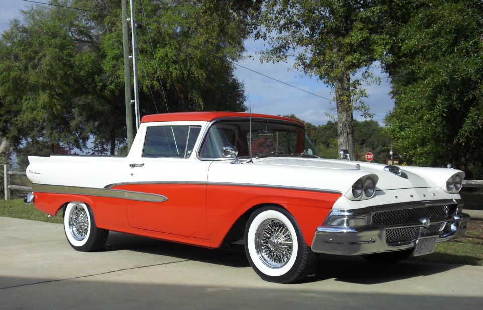1958 Ford Ranchero, white and orange, parked outside.
