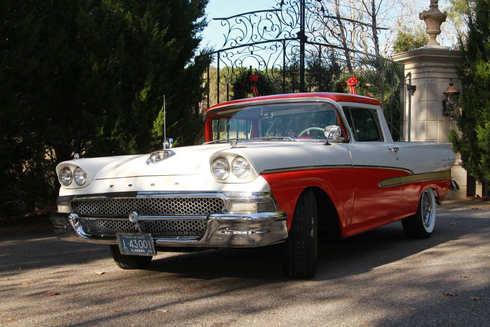 Two-tone red and white 1957 Ford Fairlane Ranchero with chrome grille and bumper, parked on a driveway