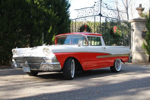 1958 Ford Ranchero - This two-tone red and white pickup truck, identified as a 1957 Ford Ranchero, is parked in front of an ornate gate.