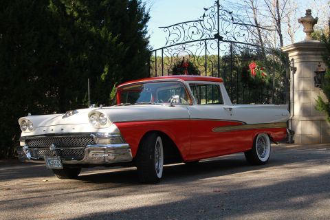 1958 Ford Ranchero - This two-tone 1958 Ford Ranchero features a distinctive body style and whitewall tires, parked in front of an ornate gate.
