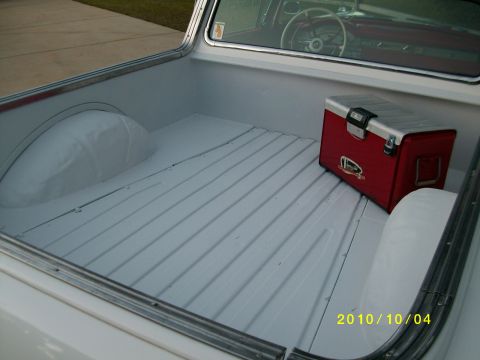 1958 Ford Ranchero - The bed of a 1958 Ford Ranchero, a red cooler and clean white flooring.