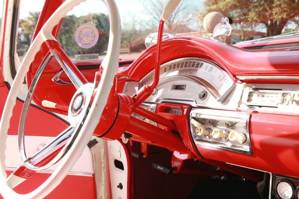 red and white steering wheel, dashboard with gauges and radio, and shifter