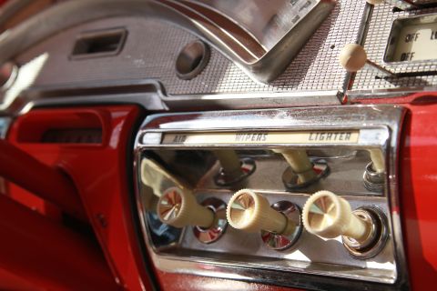 1958 Ford Ranchero - Close-up of a 1958 Ford Ranchero interior, showing the dashboard controls and red painted surfaces.