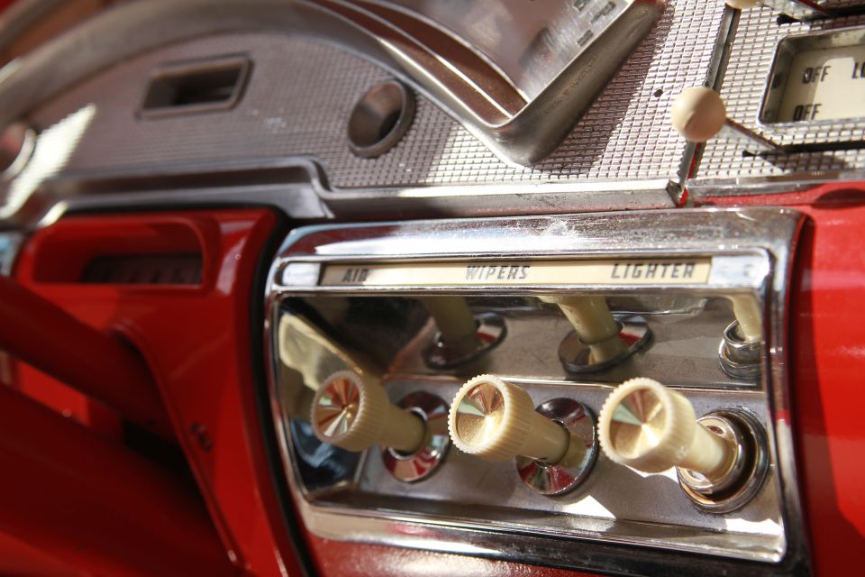 1958 Ford Ranchero dashboard with red trim, chrome accents, and bakelite knobs for air, wipers, and lighter