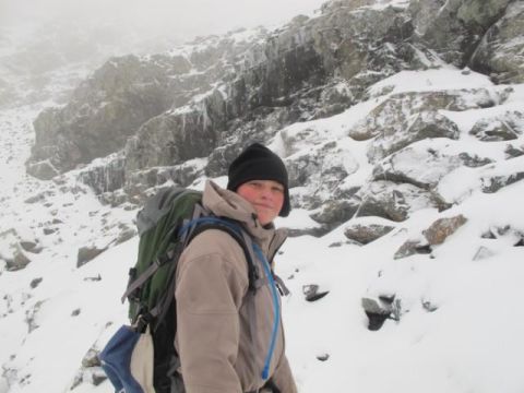 1996 Ford Bronco - A person stands in a snowy mountain landscape, wearing winter clothing and a large backpack.