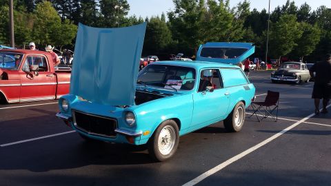 1976 Ford Ranchero - A blue panel van is displayed with its hood and rear hatch open at an outdoor event.