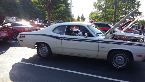 1976 Ford Ranchero - A white coupe with black racing stripes and a '340' decal is parked at a car show with its hood open.