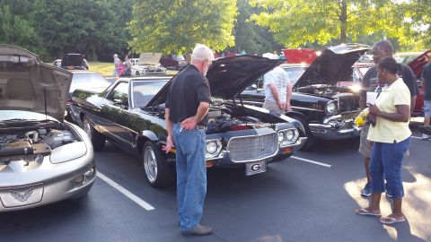 1976 Ford Ranchero - A black Ford Ranchero is displayed with its hood open at an outdoor car show.