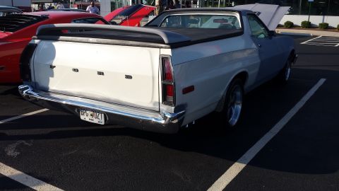 1976 Ford Ranchero - This 1976 Ford Ranchero is seen from the rear, a white bed and blue cab, parked next to other vehicles.