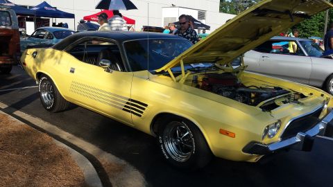 1976 Ford Ranchero - Yellow 1970s muscle car with hood open at an outdoor car show.