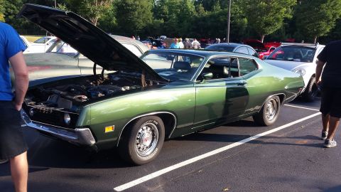 1976 Ford Ranchero - A green coupe is parked with its hood up, showing the engine bay.