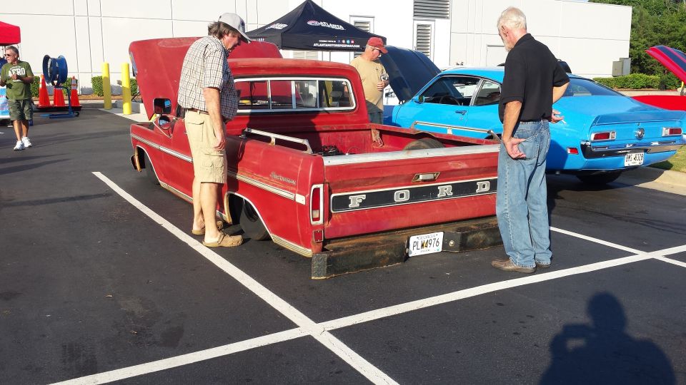 Red Ford pickup truck, rear view, with a lowered stance and a black bumper