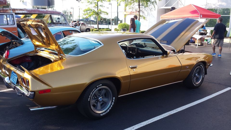 Gold 1970s coupe with hood and trunk open, showing racing stripes on hood