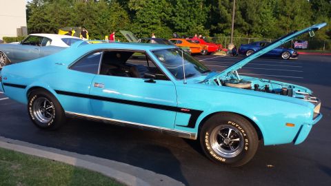 1976 Ford Ranchero - A light blue AMC Javelin is parked with its hood up, showing off its engine bay.