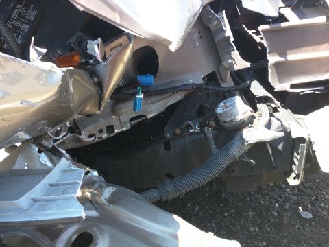 2007 Ford Crown Victoria - Front end damage to a vehicle, with visible bent metal and electrical components.