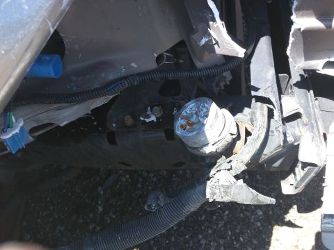 2007 Ford Crown Victoria - The front end of a vehicle is heavily damaged, with exposed wiring and a broken light fixture visible.
