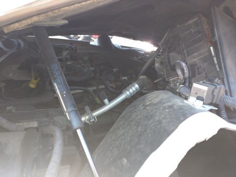 2007 Ford Crown Victoria - The engine compartment of a 2007 Ford Crown Victoria shows damage and exposed parts.