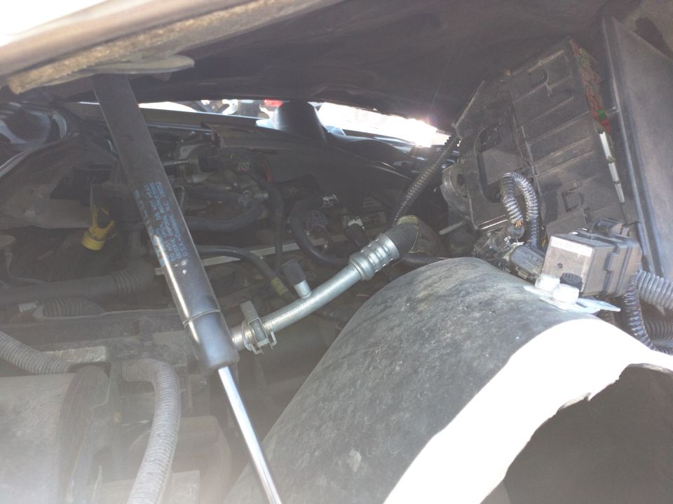 2007 Ford Crown Victoria engine compartment with damaged hood support and exposed engine components