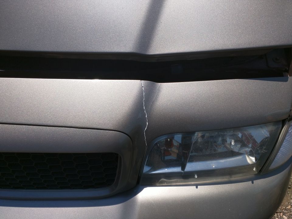 Grey car hood cracked near headlight