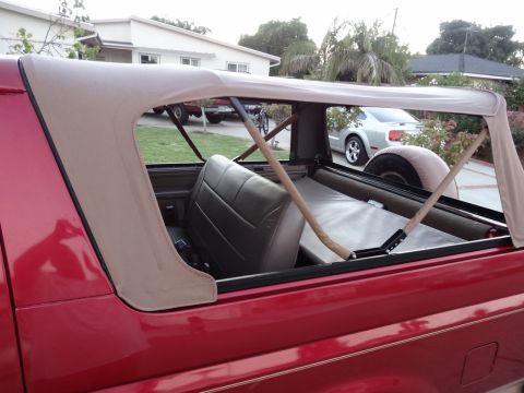 1994 Ford Bronco - This 1994 Ford Bronco features a removable tan soft top, offering an open-air driving experience.