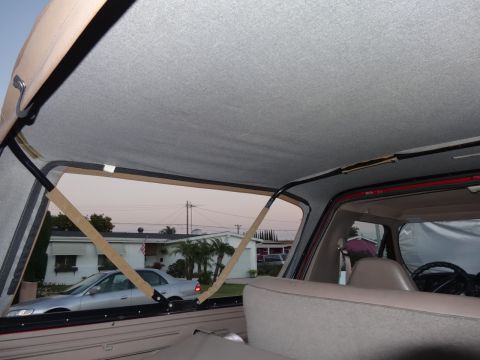 1994 Ford Bronco - View from inside a vehicle with a soft top, looking out at a residential street.