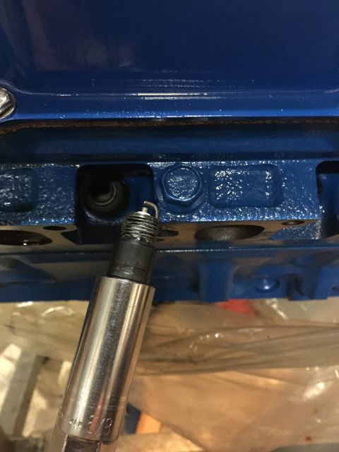 1978 Ford Bronco - Spark plug installation into a blue engine block.