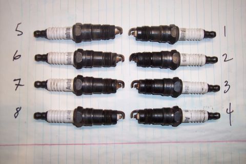 1990 Ford Bronco - Eight spark plugs are arranged in two columns on a piece of lined paper, each labeled with a number.