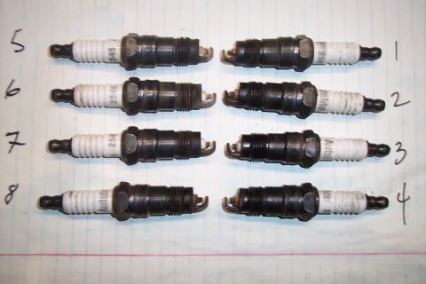 1990 Ford Bronco - Eight spark plugs are arranged in two columns on a piece of lined paper.