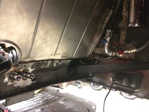 1964 Ford Fairlane - Underneath view of a vehicle's chassis showing fuel or brake lines connected to a metal panel. Visible components include metal tubing, val…