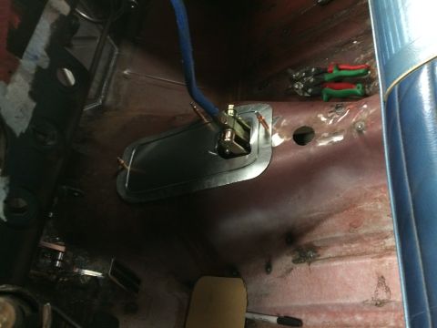 1964 Ford Fairlane - The interior floor of a vehicle is shown, with a metal plate installed around a shifter mechanism. Various tools are visible in the backgro…