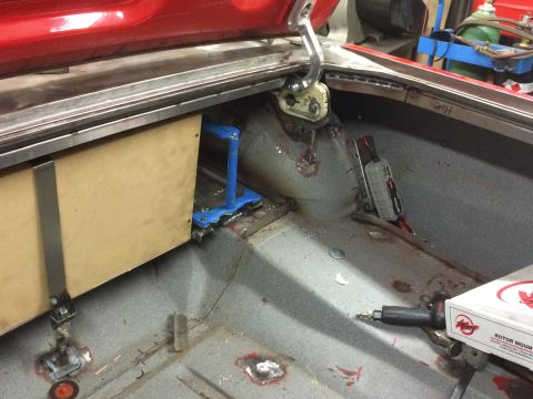 1964 Ford Fairlane - The interior of a classic car trunk is shown, with a wooden box mounted on the left side and various tools and parts on the floor. The red…