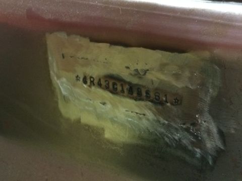 1964 Ford Fairlane - A close-up view shows a VIN plate with the number *6R43G148581* stamped into it. The plate appears to be attached to a car's body panel, po…