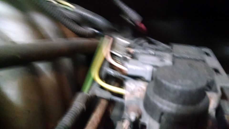 Blurry close-up of electrical wires and a component in a vehicle.