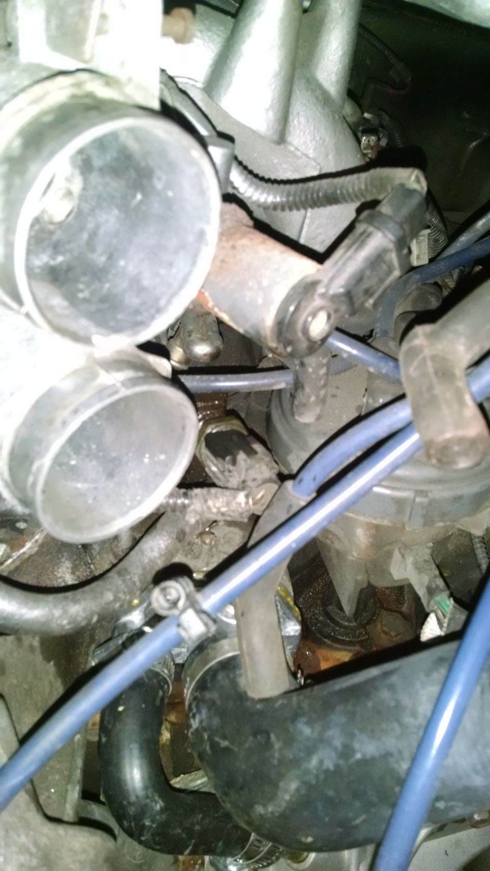 Engine bay close-up with hoses, pipes, and sensors