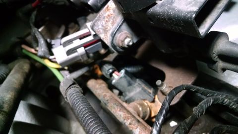 1995 Ford Bronco - A close-up view of automotive wiring harnesses and connectors, likely from a 1995 Ford Bronco engine bay. The image shows various wires, a…