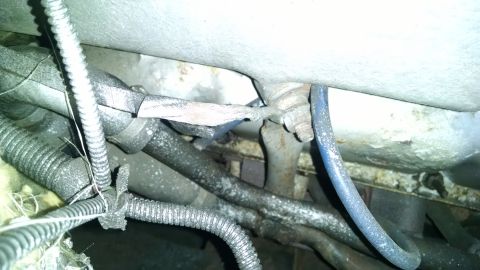 1995 Ford Bronco - This image shows a close-up view of various hoses and cables, possibly from the engine bay or undercarriage of a vehicle. A blue hose is pr…