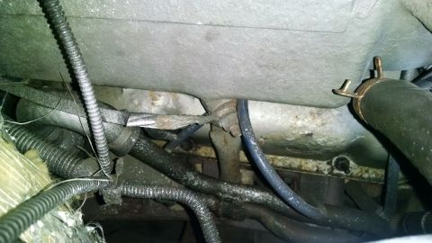 1995 Ford Bronco - This image shows a close-up view of the engine bay of a 1995 Ford Bronco, focusing on various hoses, wires, and metal components. The engin…