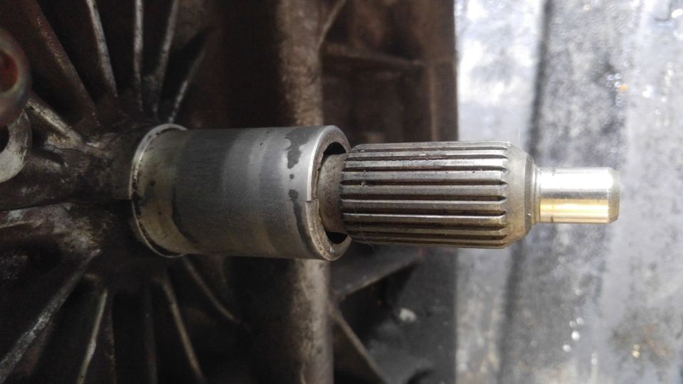 Close-up of a splined shaft extending from a metal housing.