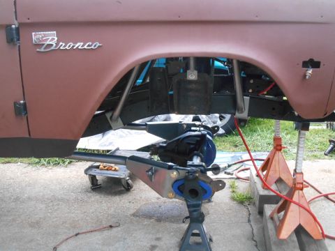 1972 Ford Bronco - The underside of a classic Ford Bronco is shown, with the rear axle assembly being worked on and supported by jack stands. The vehicle's bo…