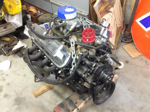 1964 Ford Fairlane - A Ford V8 engine with chrome valve covers that read "Ford Racing" is shown in a garage setting. The engine features a blue air filter, a re…