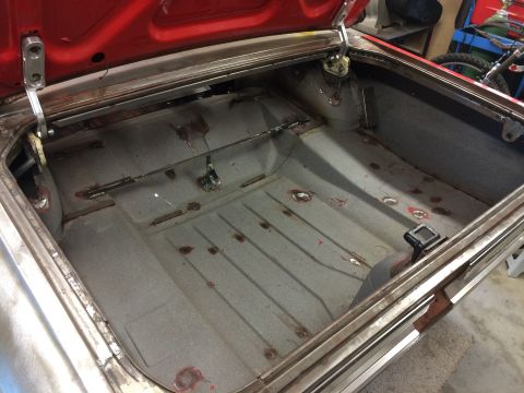 1964 Ford Fairlane - The open trunk of a classic car, likely a 1964 Ford Fairlane, shows the interior floor and trunk lid hinges. The trunk floor appears to be…