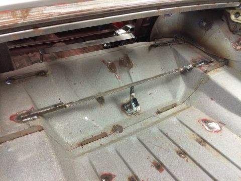 1964 Ford Fairlane - The interior of a classic car's trunk area is shown, featuring metal floor repairs and reinforcements with visible welds. A thin metal bar…