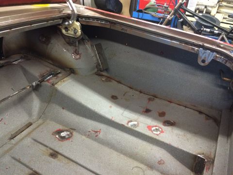 1964 Ford Fairlane - The interior of a classic car's trunk area is shown, with visible metalwork and welding repairs on the floor and wheel wells. The trunk lid…