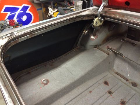 1964 Ford Fairlane - The interior of a classic car's trunk area is shown, with exposed metal, welding marks, and a black liner visible. A large orange and blue…