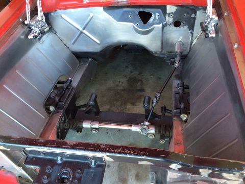 1964 Ford Fairlane - A view of the engine bay of a classic car undergoing restoration. The firewall and inner fenders have been cleaned and appear to be sheet m…