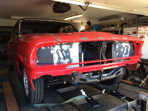 1964 Ford Fairlane - A red 1964 Ford Fairlane is shown from the front three-quarter view, partially disassembled on a trailer. The front end is missing its gril…