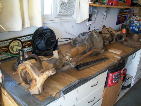 1991 Ford Bronco - A workbench displays disassembled front axle components and a small black fan. The parts appear to be from a 1991 Ford Bronco, as indicated…