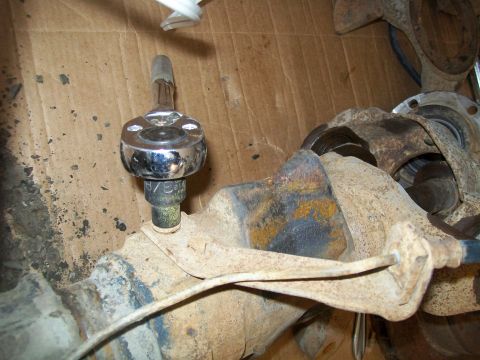 1991 Ford Bronco - A close-up shot shows a socket wrench with a 13/16 socket attached to a rusty metal component of a vehicle's drivetrain, likely an axle hou…